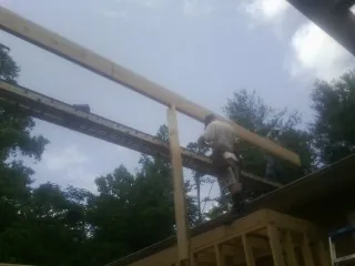 Carpenter setting a ridge beam over a new addition frame — Ice Dam Removal by Roofing Brothers in Florence