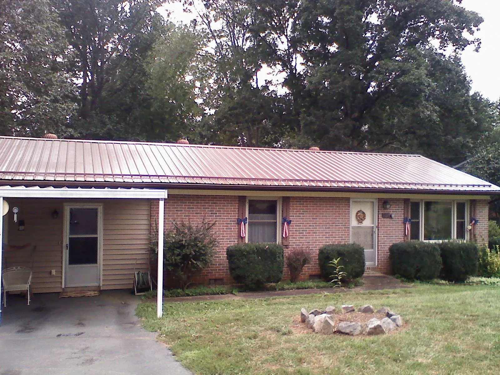 Bronze metal roof and carport on a brick ranch home — Roof Repair work by our crew in Florence